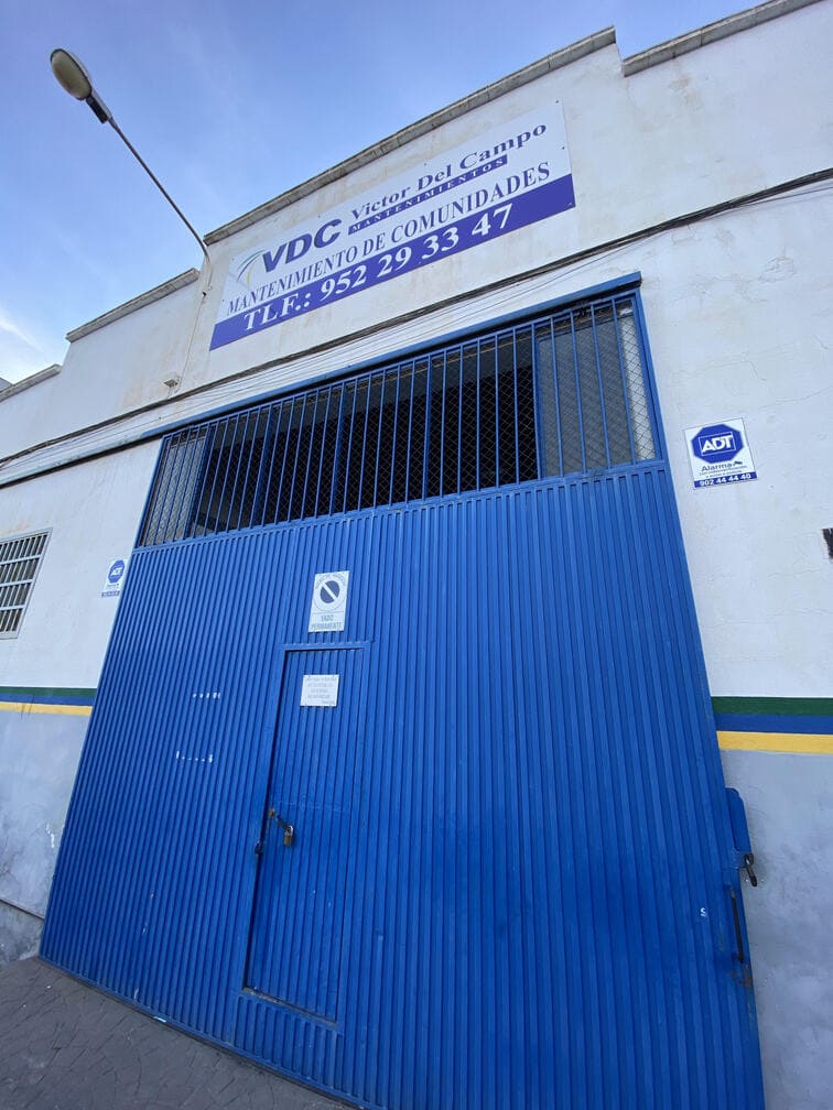 Puerta azul de la nave industrial de Víctor del Campo Mantenimiento con logotipo - Mantenimiento grupo de presión en Málaga